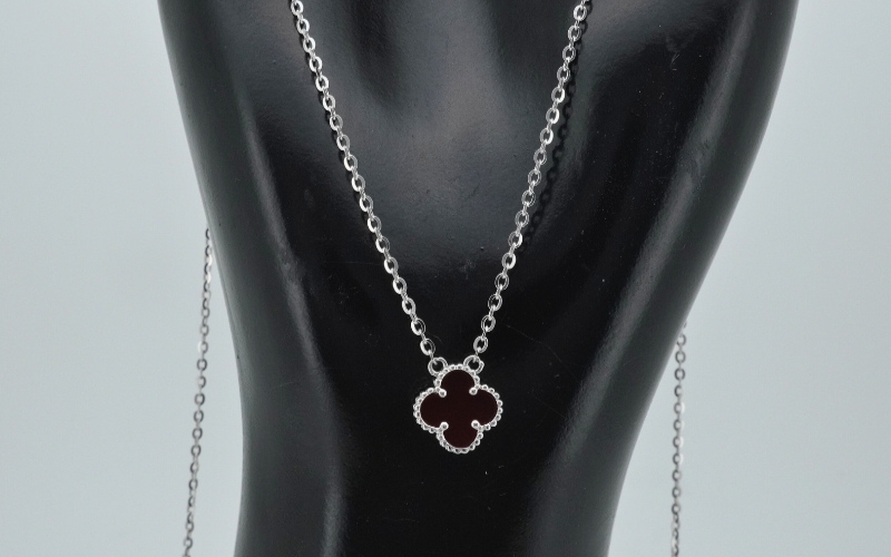 Trang Sức Cỏ 4 Lá - Biểu Tượng May Mắn Và Phong Cách Của Thời Trang Cao Cấp 2 Cận Cảnh Dây Chuyền Trang Sức Cỏ 4 Lá Mặt Đá Màu Đỏ Sẫm Phối Cùng Dây Mảnh Tinh Tế Trên Cổ Ma-Nơ-Canh Trưng Bày.